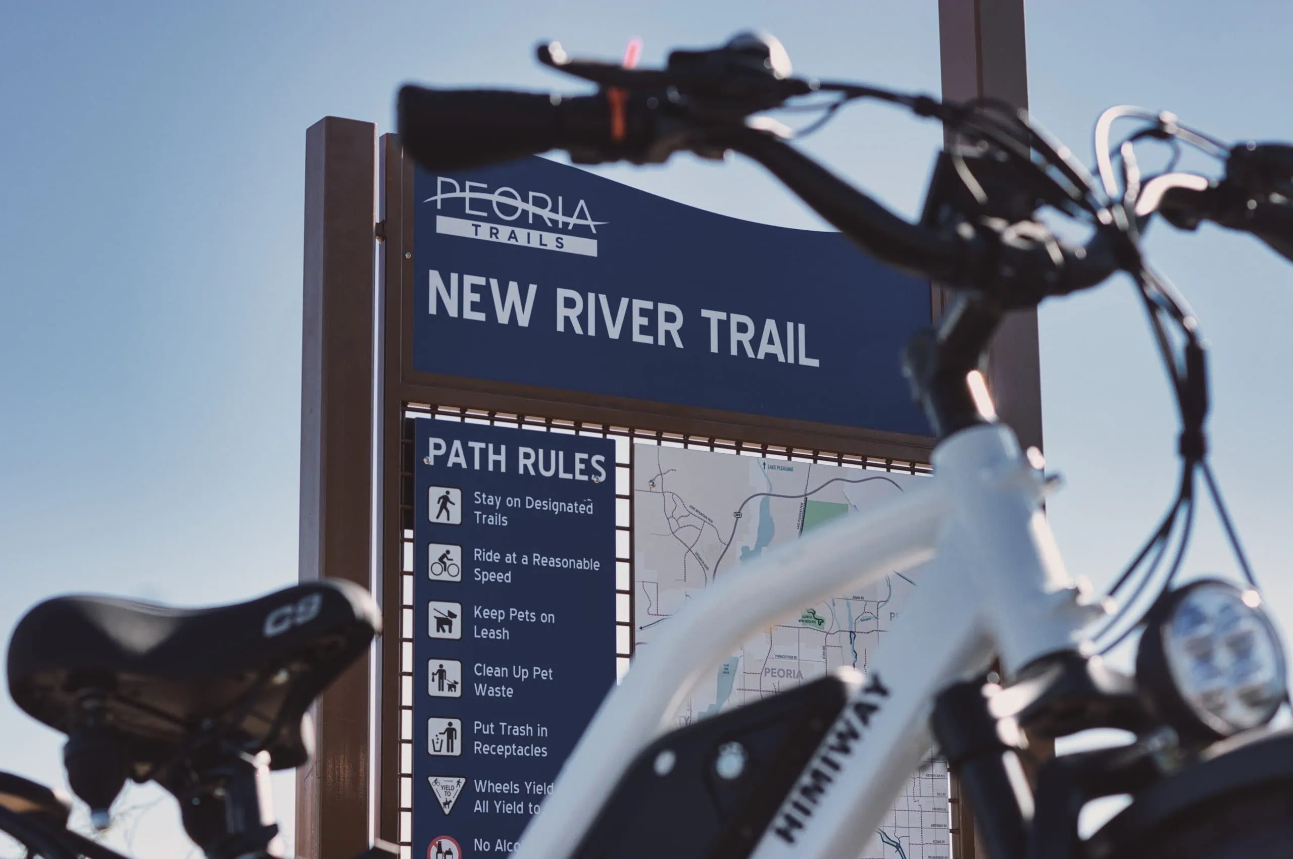Smitty's rental e-bike in front of the New River Trail sign in Peoria