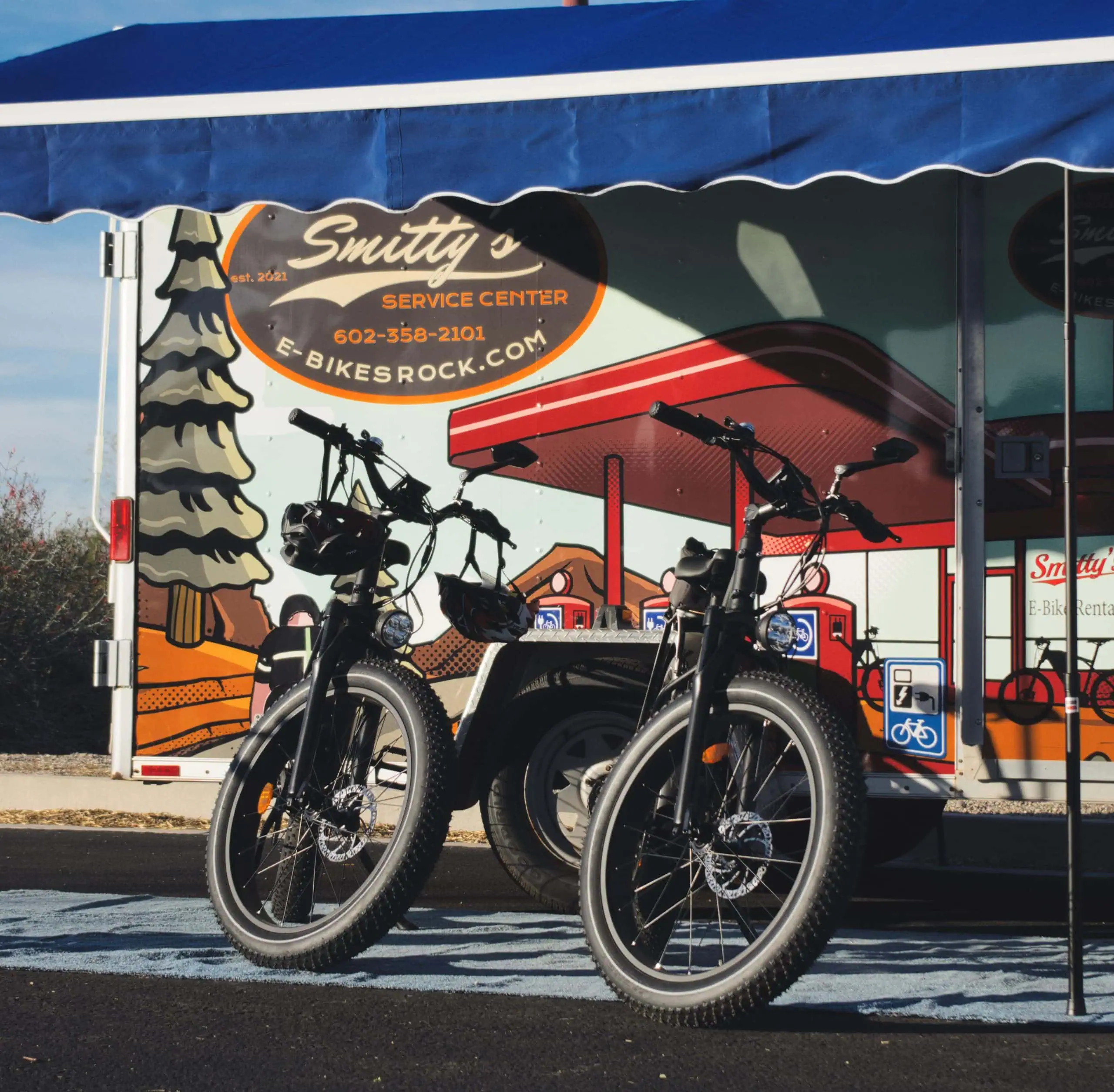 Electric mountain bikes showcased in front of Smitty's Bike Service Center, promoting fun and sustainable riding.