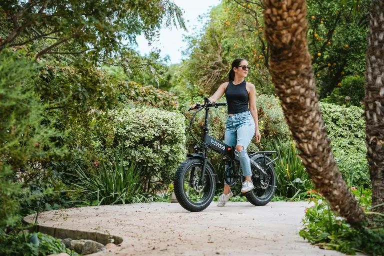 Woman riding electric bike through lush botanical garden, eco-friendly transportation, outdoor adventure.