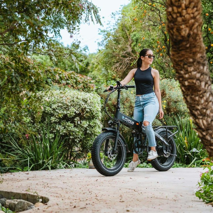 Woman riding electric bike through lush botanical garden, eco-friendly transportation, outdoor adventure.